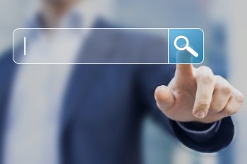 Mann im Anzug klickt auf virtuelles Suchfeld