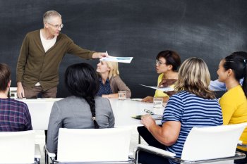 Dozent verteilt Papiere an Studierende